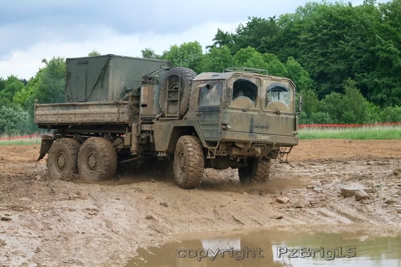 a lot of old military vehicles of the german army drive to the mud